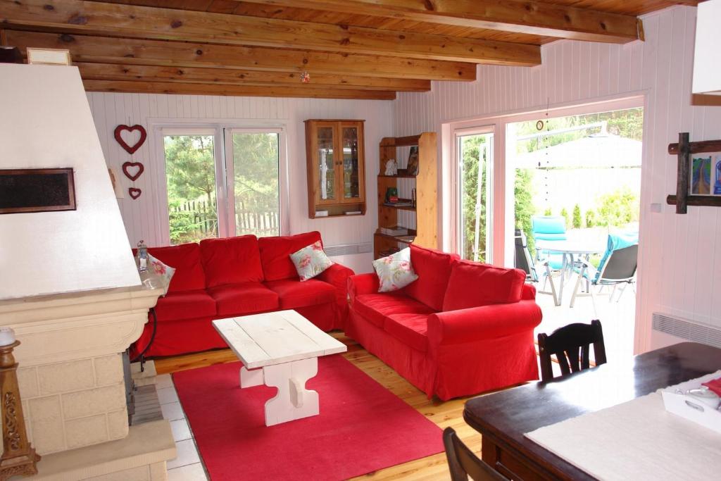 een woonkamer met rode banken en een tafel bij Qubalonka Saunarium Bory Tucholskie in Bak