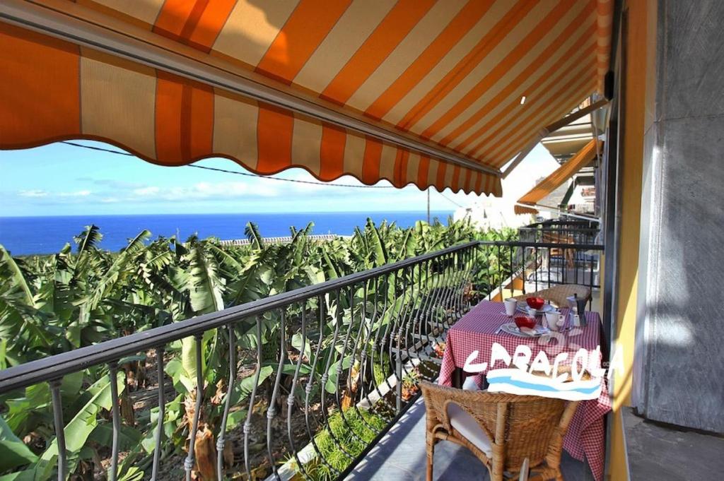 a table on a balcony with a view of the ocean at Caracol Trail Mountain La Palma junto a Trebol in Tazacorte