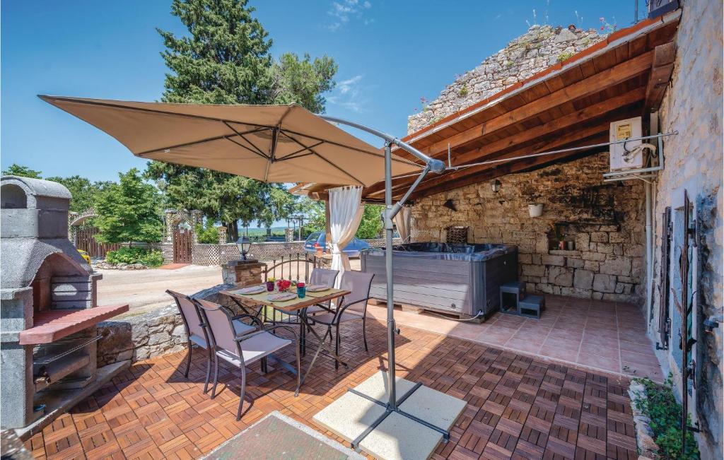 - une terrasse avec une table, un parasol et un grill dans l'établissement 1 Bedroom Amazing Home In Bacva, à Bačva