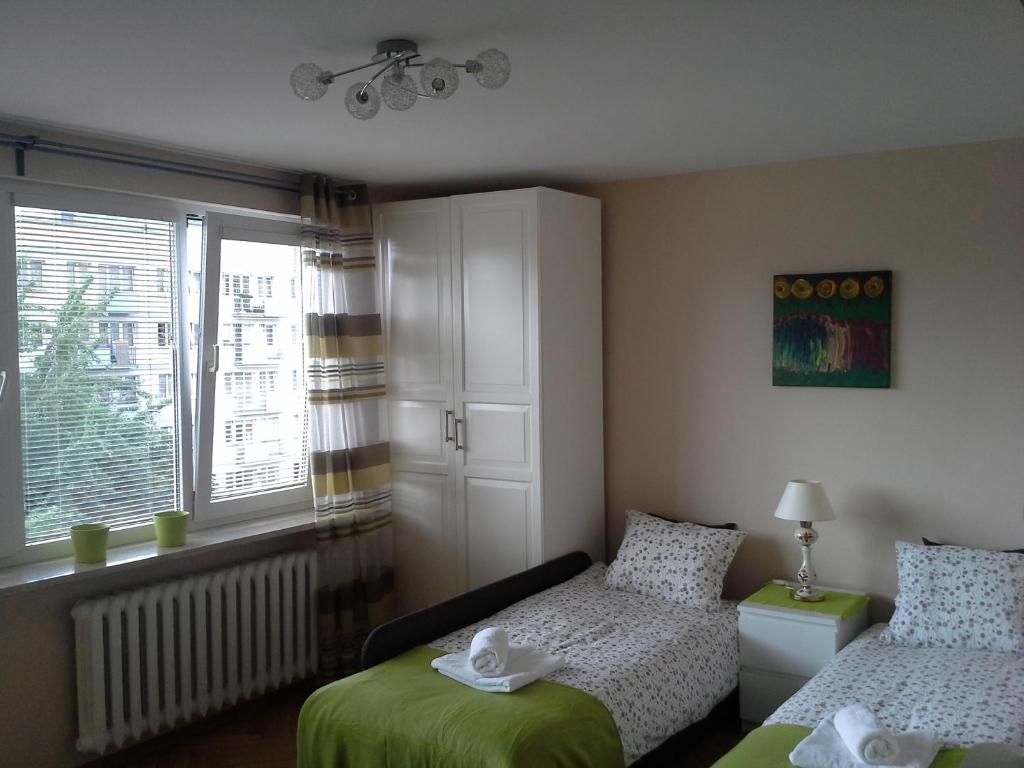 1 dormitorio con 2 camas y ventana en Studio Green, en Varsovia