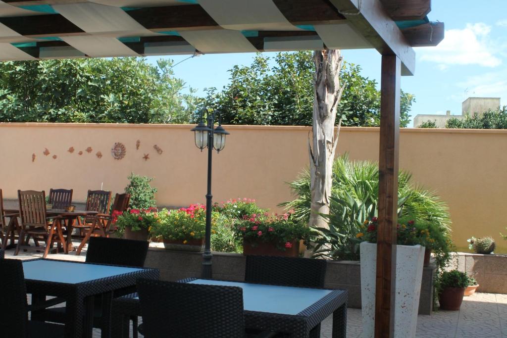 un patio con mesas y sillas y una valla en B&B Zahir, en Castro di Lecce