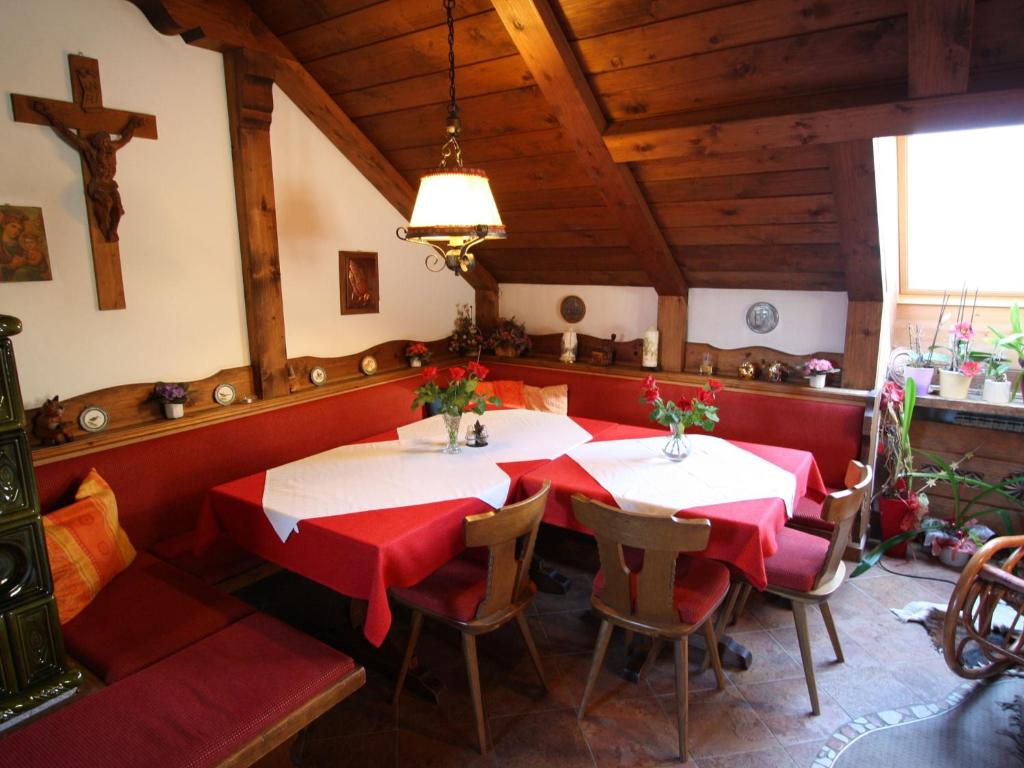 uma sala de jantar com duas mesas e cadeiras vermelhas em Apartment near the ski area in Salzburg em Sankt Michael im Lungau