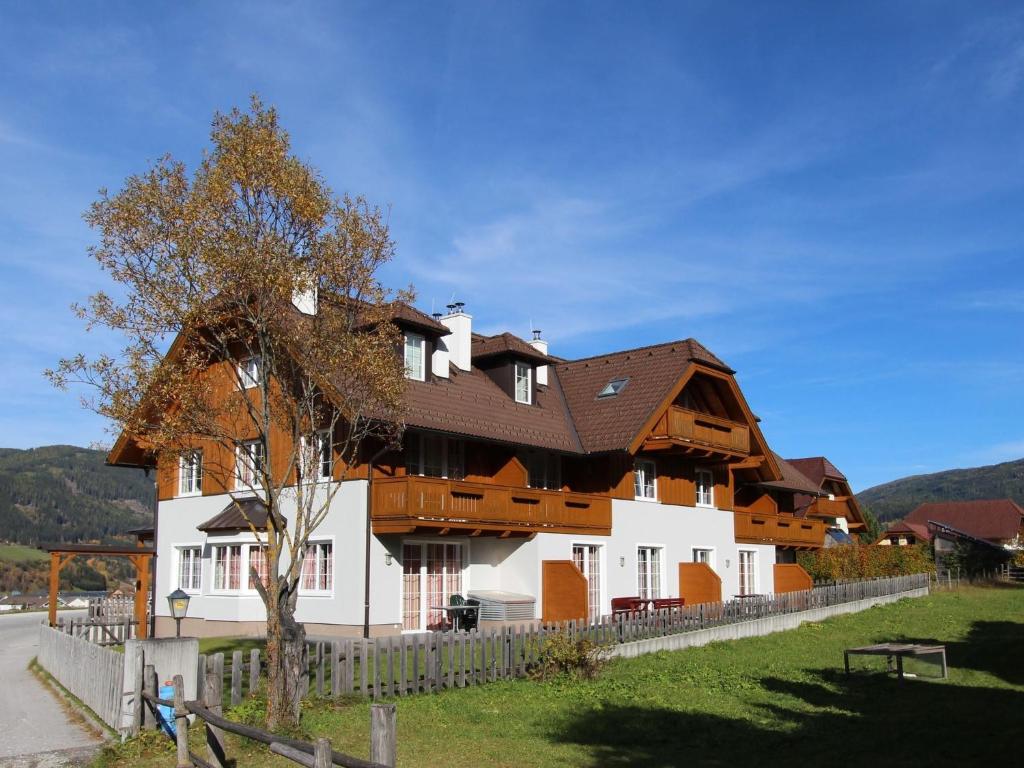 a large white house with a wooden roof at Modern Apartment in Sankt Margarethen im Lungau with Garden in Sankt Margarethen im Lungau