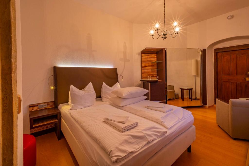 a bedroom with a large bed with white sheets at Wasserschloss Podelwitz in Colditz