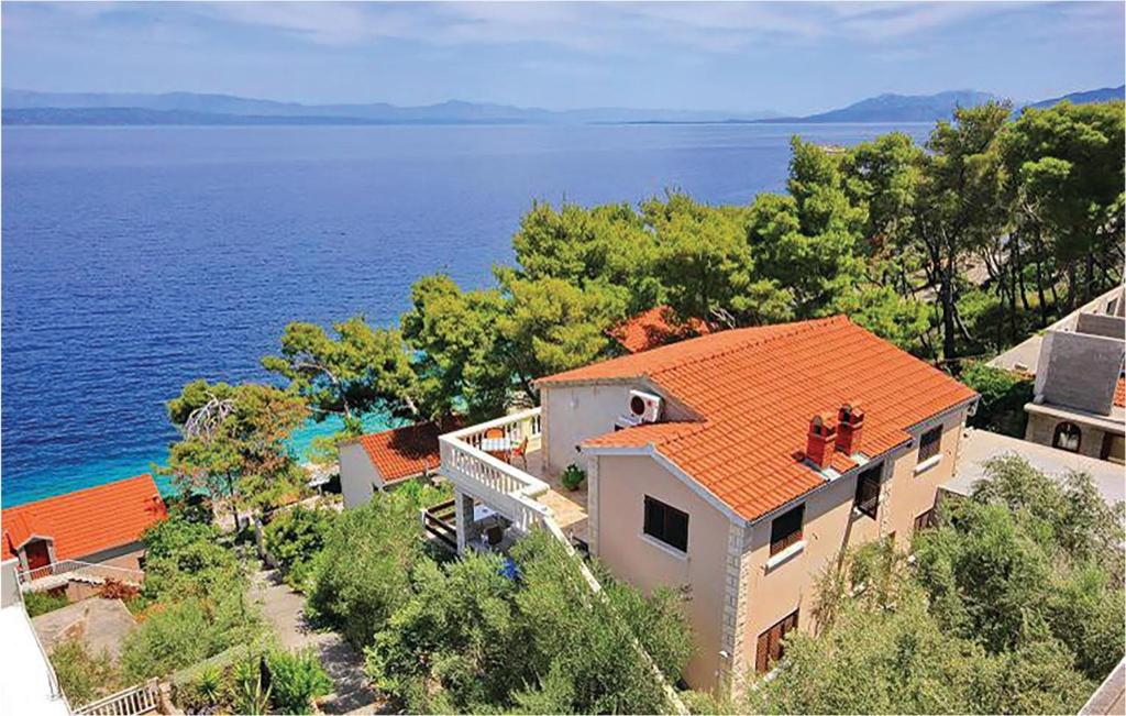 a house with an orange roof next to the water at Amazing Apartment In Prigradica With House Sea View in Prigradica