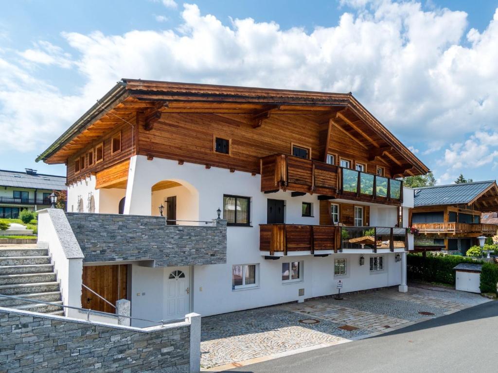 uma casa grande com um telhado de gambrel e madeira em Apartment near the Hahnenkamm cable car em Kitzbühel