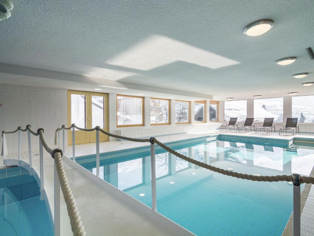 a large swimming pool with blue tiles in a building at Quaint Apartment with Sauna in Riezlern in Riezlern