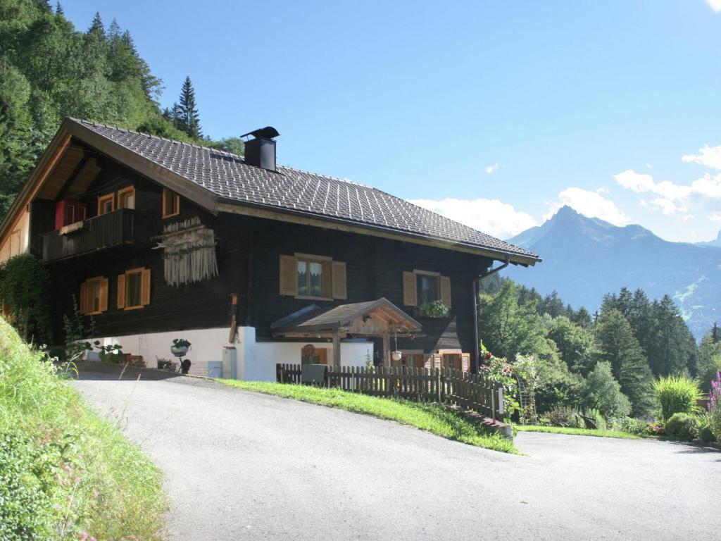 a house on a road with mountains in the background at Apartment with view of Schruns in Schruns-Tschagguns
