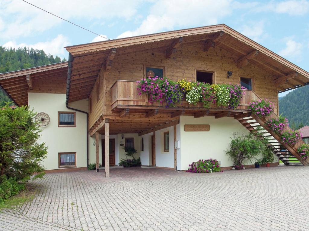 ヴァイトリングにあるCharming Apartment with Shared Pool in Waidring Tyrolの花が咲くバルコニー付きの建物