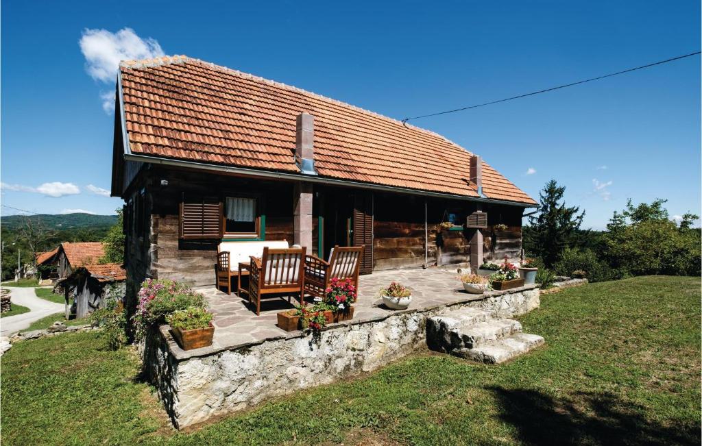 een klein huis met een stenen muur en stoelen bij Gorgeous Home In Ozalj With House A Panoramic View in Ozalj