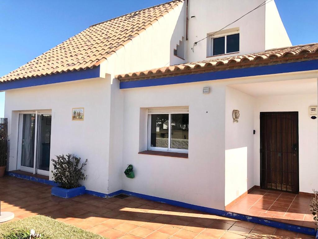 een wit huis met een bruine deur bij Estepona Villa Sea Front in Estepona