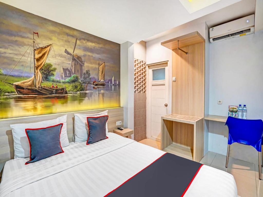 a bedroom with a bed with a painting on the wall at Capital O 90888 Bintang Diponggo Residence in Surabaya