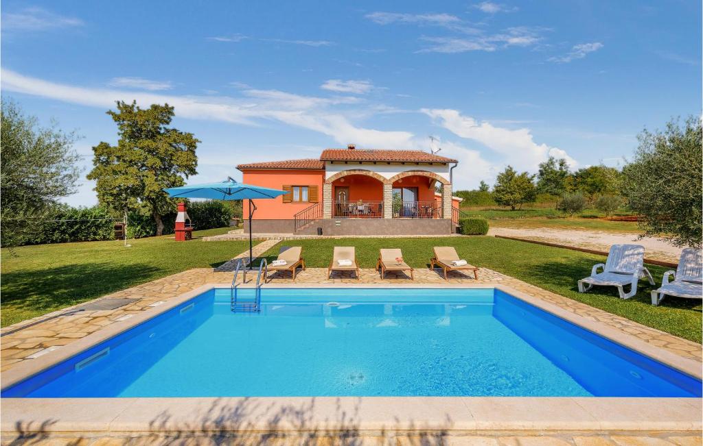 a swimming pool in front of a house at Beautiful Home In Visnjan With Outdoor Swimming Pool in Višnjan