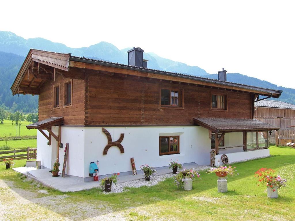 a house with a wooden roof and a yard at Spacious Apartment with Sauna in Leogang in Leogang