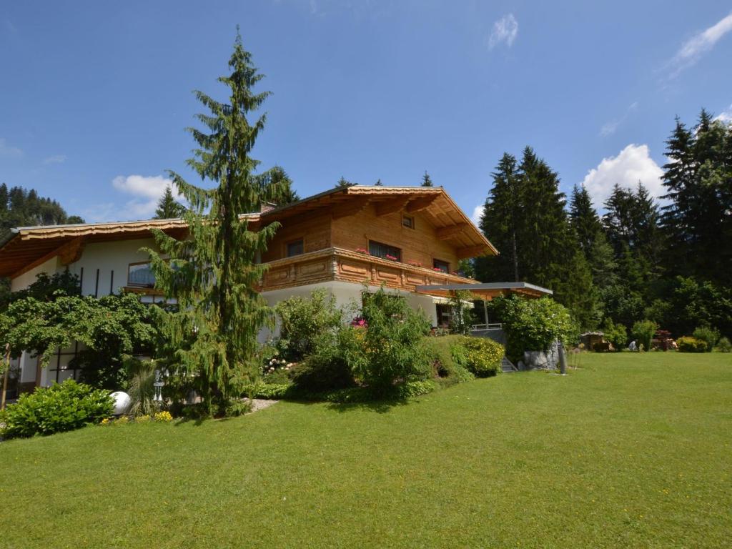 ein Haus mit grünem Rasen davor in der Unterkunft Apartment in W ngle Tyrol with Walking Trails Near in Reutte