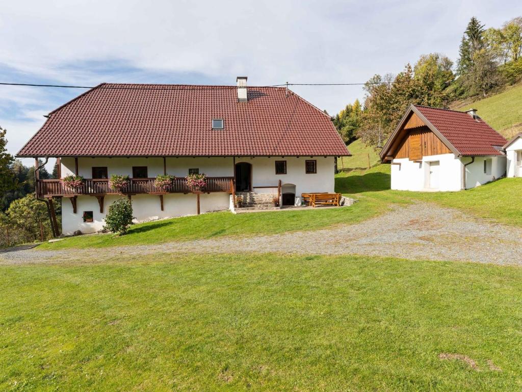 Biały dom z czerwonym dachem na wzgórzu w obiekcie Holiday home in Eberstein Carinthia with sauna w mieście Eberstein