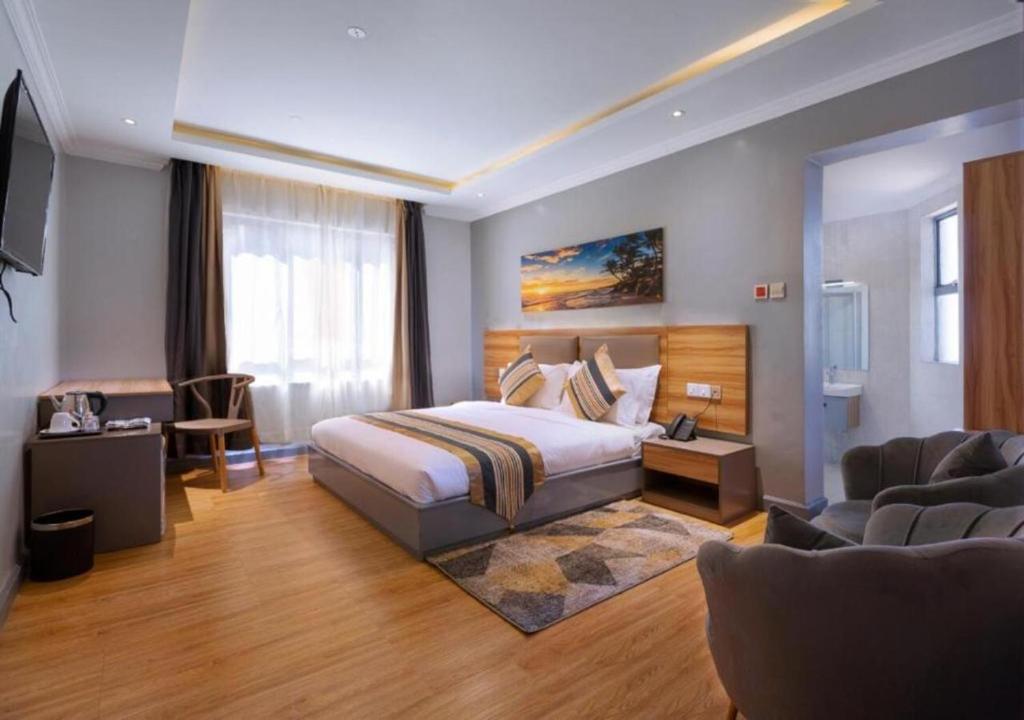 a hotel room with a bed and a living room at Raha Suites - Westlands 