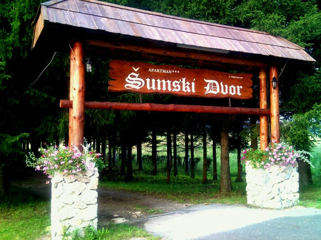 a sign for a resort with flowers on it at Guest House Šumski dvor in Vrhovine