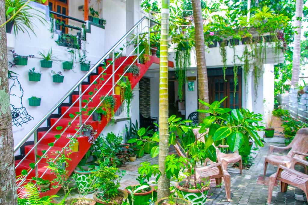 a red staircase in a building with plants at Sigiri Tarushan Home Stay in Sigiriya