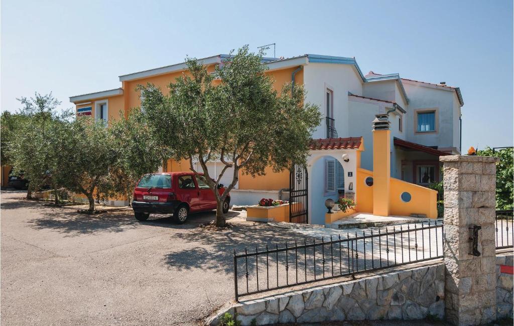 czerwony van zaparkowany przed domem w obiekcie One-Bedroom Apartment In Posedarje w mieście Posedarje