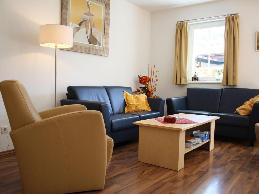 ein Wohnzimmer mit blauen Sofas und einem Couchtisch in der Unterkunft Apartment in Kaprun near ski lift in Kaprun