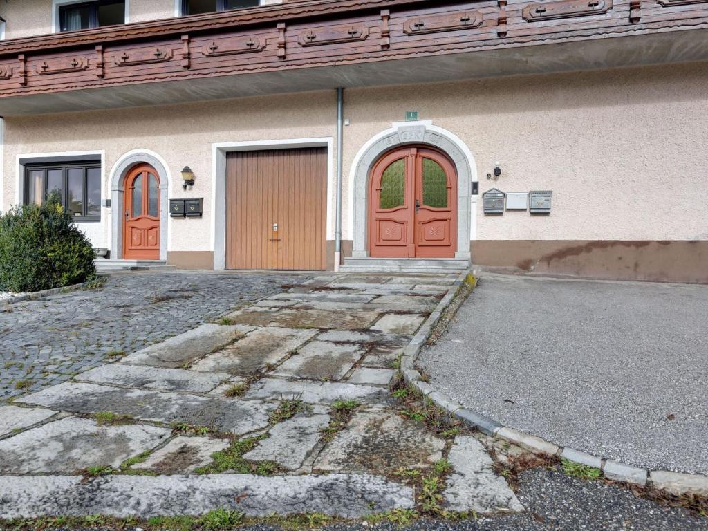 a building with orange doors and a driveway at Beautiful Holiday Home in Ulrichsberg with Balcony in Ulrichsberg