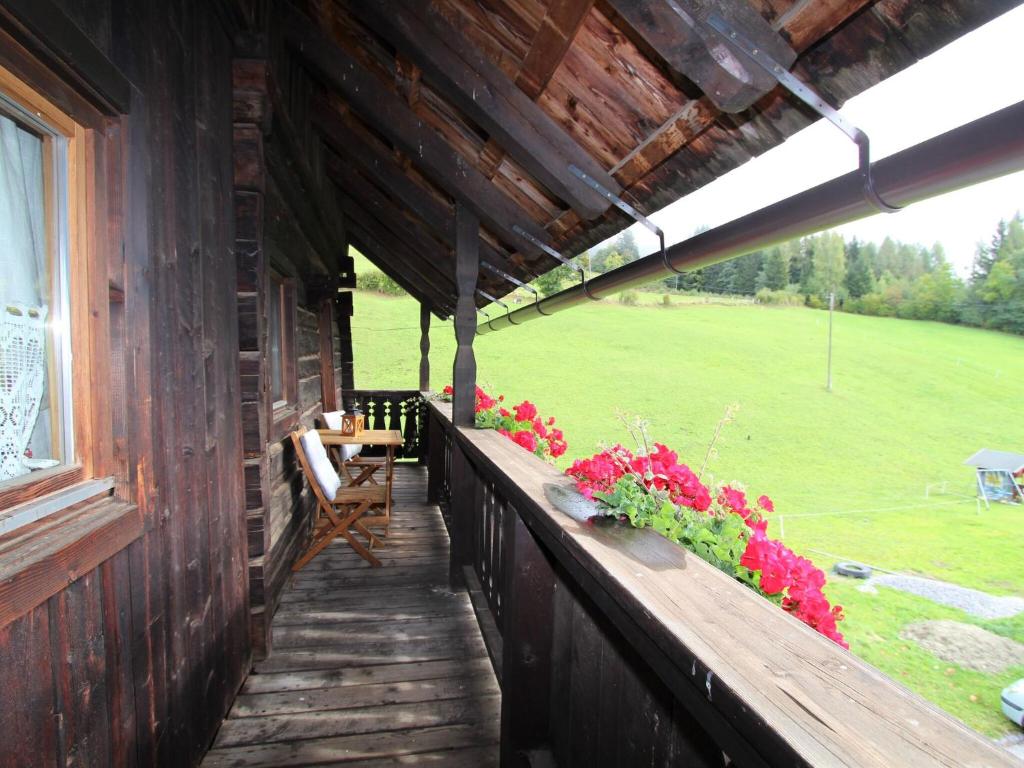 a porch of a wooden house with flowers on it at Modern holiday apartment in a renovated farmhouse in Fresach Carinthia in Fresach
