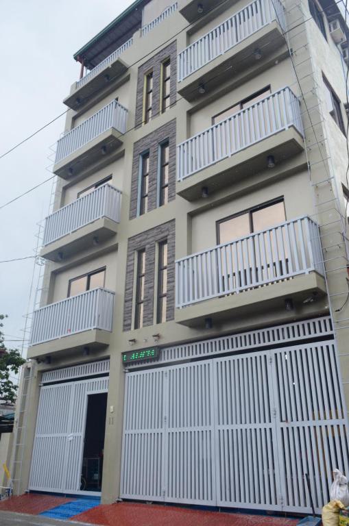 un edificio alto y blanco con balcones blancos. en Alicia Apartment en Manila