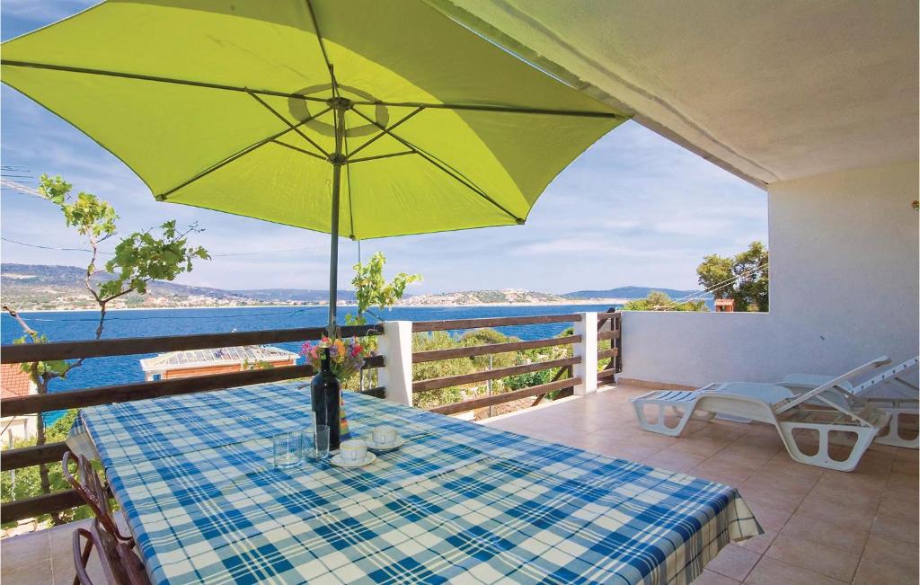 una mesa con una sombrilla amarilla en el balcón en Beautiful Apartment In Kanica With 2 Bedrooms And Wifi, en Sevid