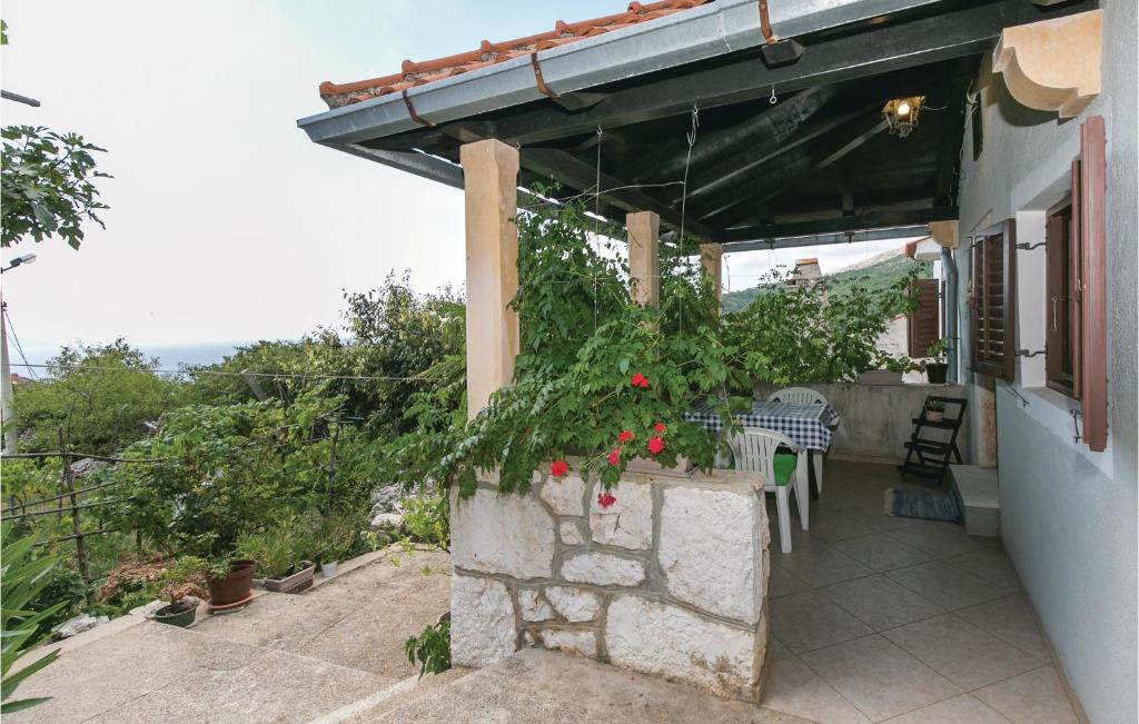 a porch of a house with a table and flowers at 1 Bedroom Pet Friendly Home In Zagorje in Zagorje