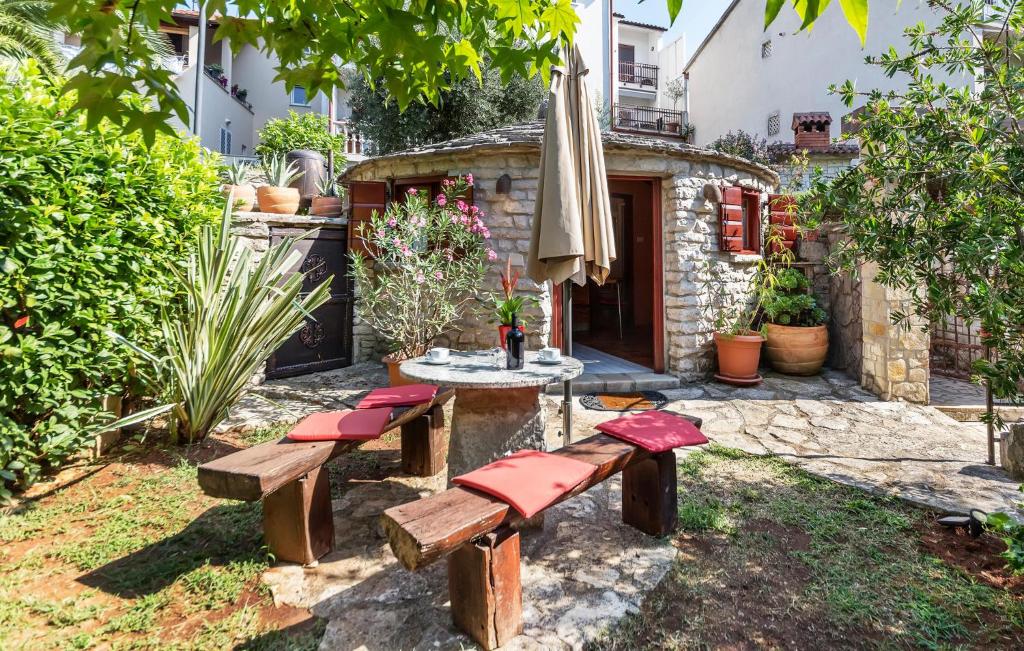 un patio con bancos, una mesa y una sombrilla en Beautiful Home In Pula With Wifi en Pula