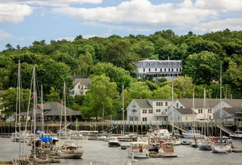 Un gruppo di barche ormeggiate in un porto con case di Relais Chateaux Camden Harbour Inn a Camden