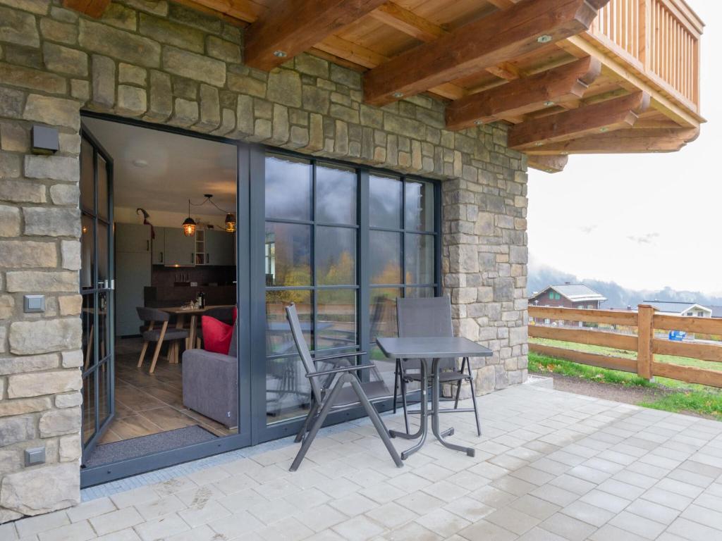 a patio with glass doors and a table and chairs at Premium Chalet in Krimml with sauna in Krimml