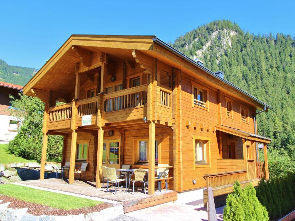 a large wooden house with a table and chairs at Comfortable Chalet with Whirlpool and Sauna in Krimml in Krimml
