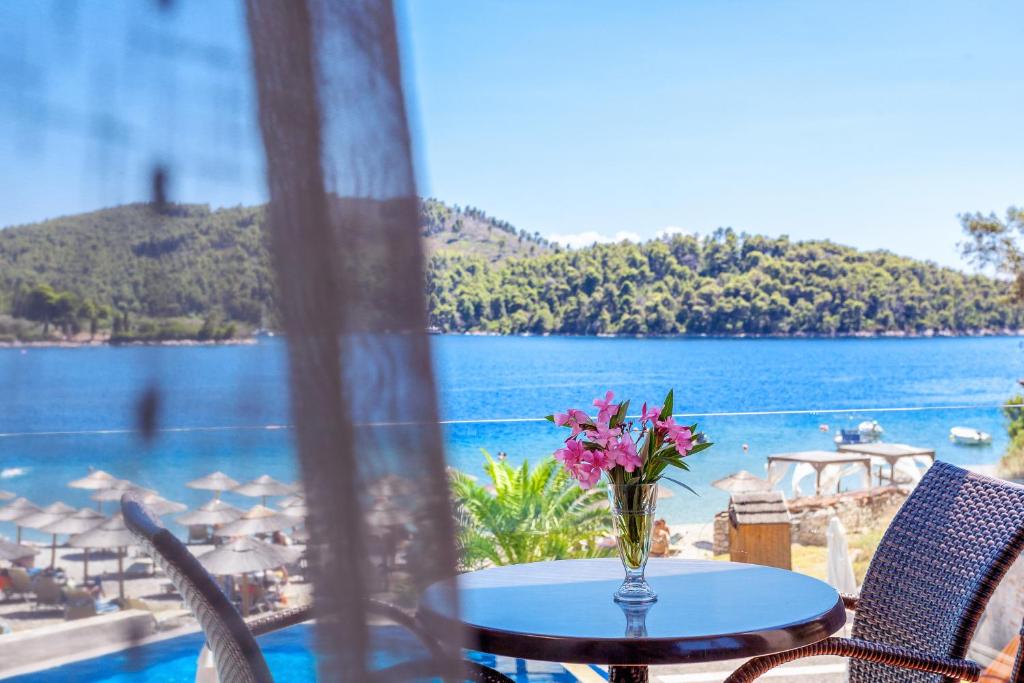 a table with a vase of flowers sitting on top of a balcony at Blue Green Bay in Panormos Skopelos