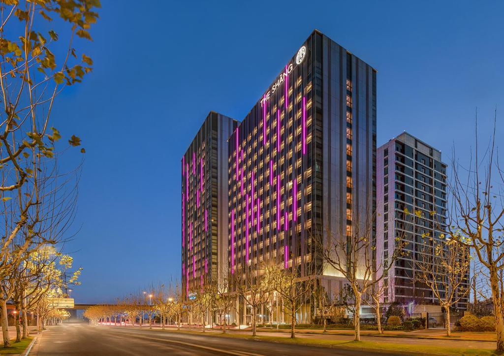 a tall building with purple windows on a city street at The Shàng by Artyzen Qiantan Shanghai in Shanghai