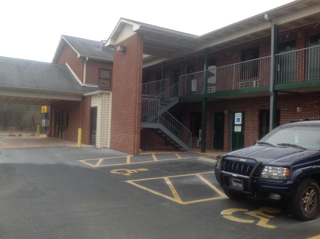 a car parked in a parking lot in front of a building at HighWay Inn in Mocksville