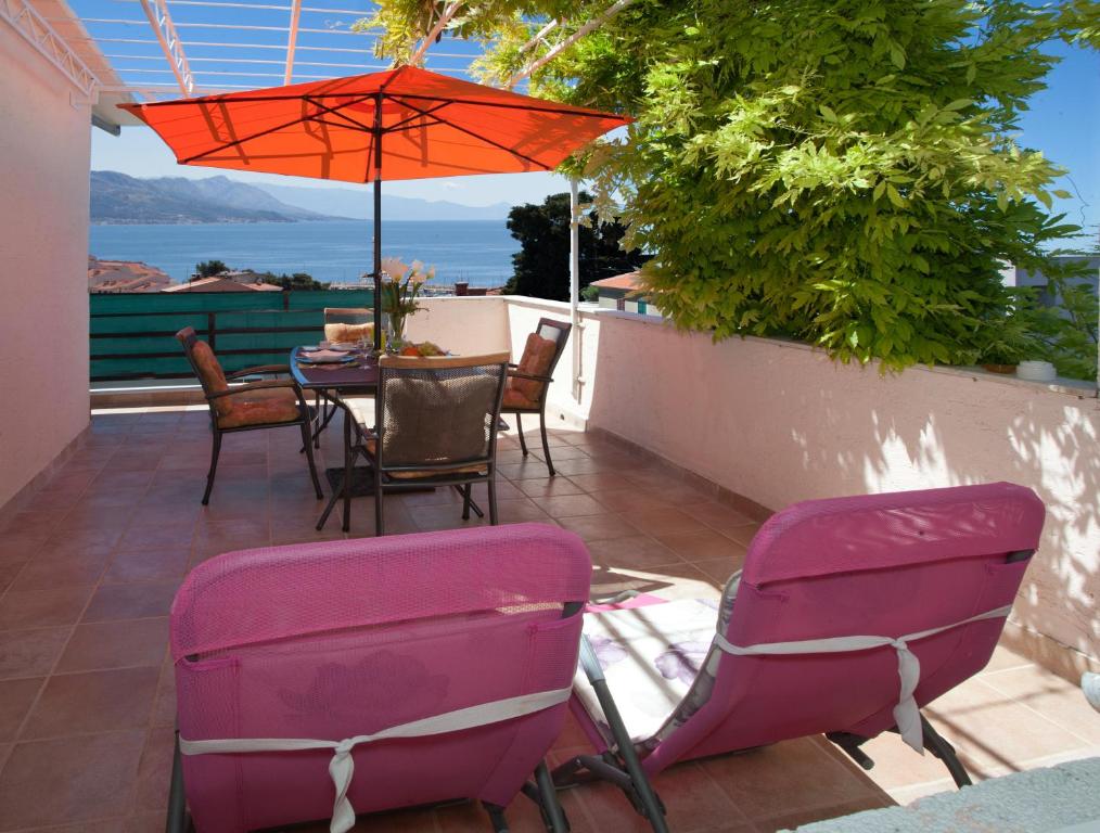 a patio with a table and chairs and an umbrella at Apartments Beautiful Sandy Beach in Split