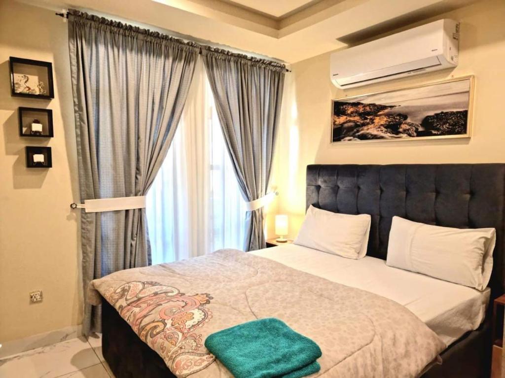a bedroom with a bed with a green towel on it at Tranquil & Delightful 1 Bed Apt In Bahria Town in Rawalpindi