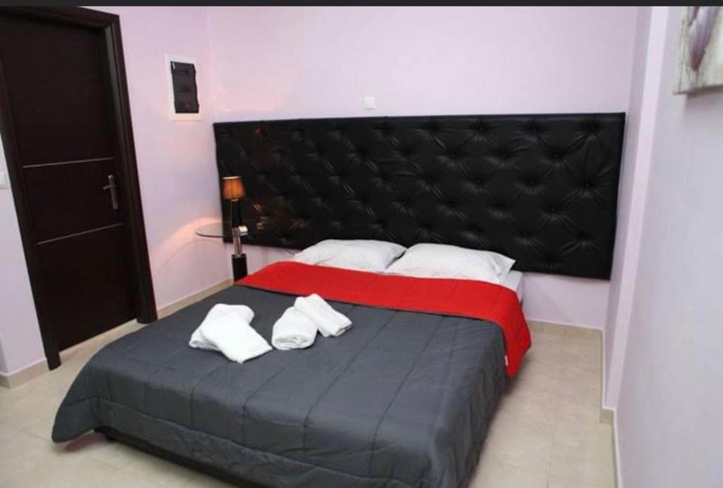 - une chambre avec un grand lit et 2 serviettes dans l'établissement Spilios Apartment, à Nauplie