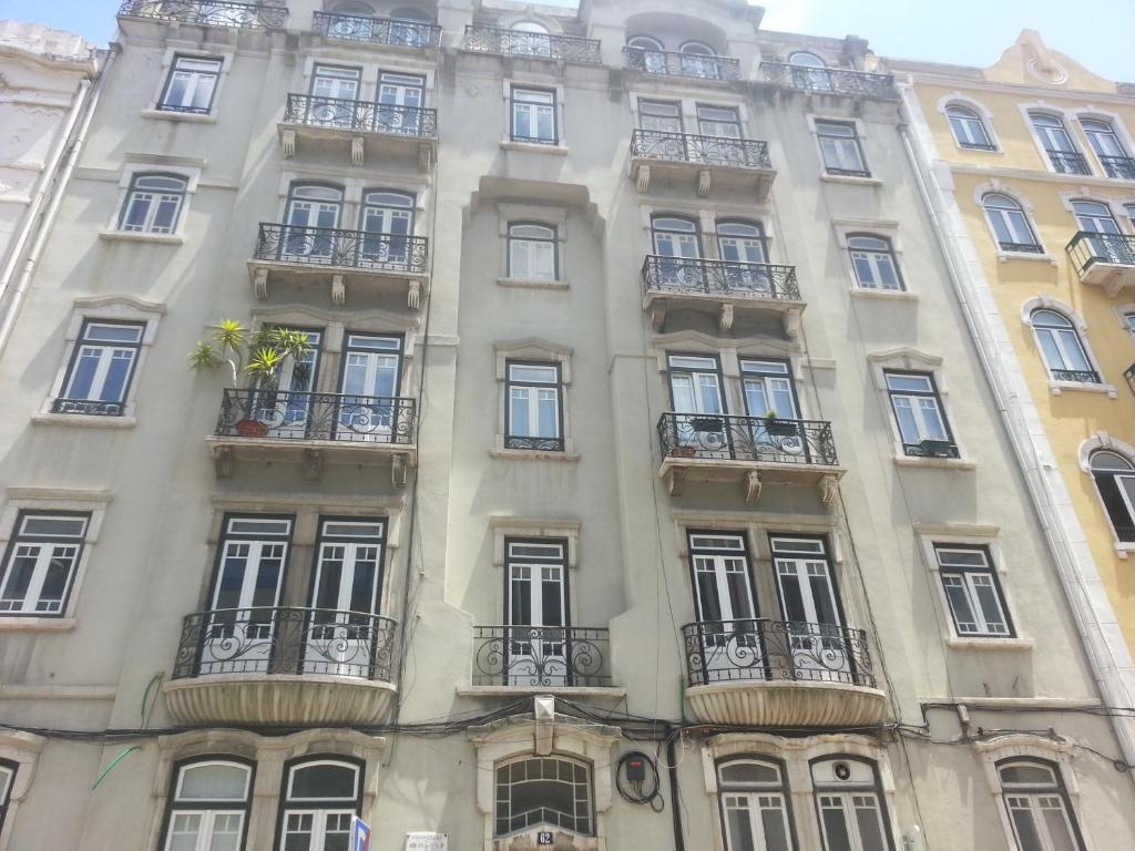 ein Apartmenthaus in Paris mit Fenstern und Balkonen in der Unterkunft Lisbon Gambori Hostel in Lissabon