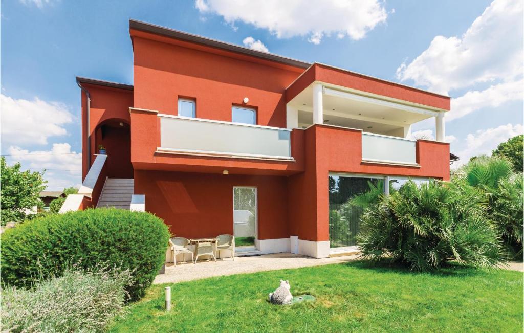 a red house with a lawn in front of it at Gorgeous Apartment In Novigrad With Kitchen in Novigrad Istria