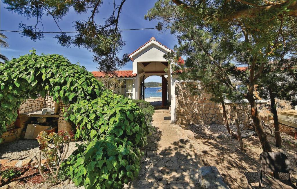 a building with a gate and a bush at Nice Home In Drvenik Mali With House Sea View in Drvenik Mali