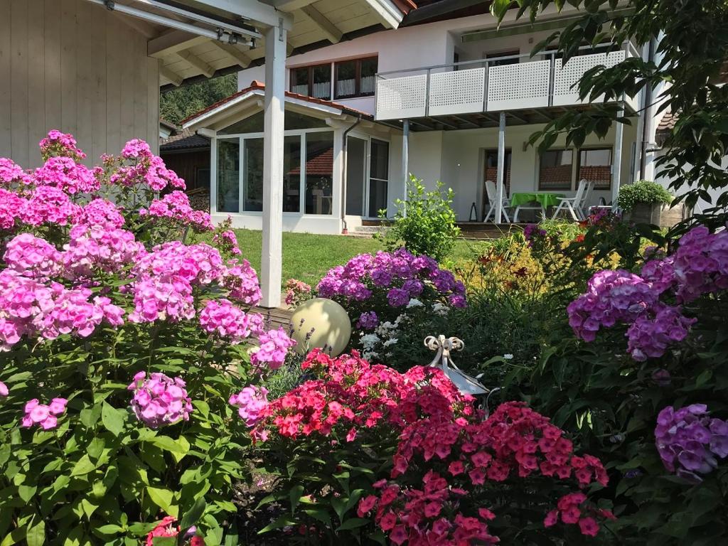 un jardín con flores rosas frente a una casa en Ferienwohnung-Fellner, en Raubling