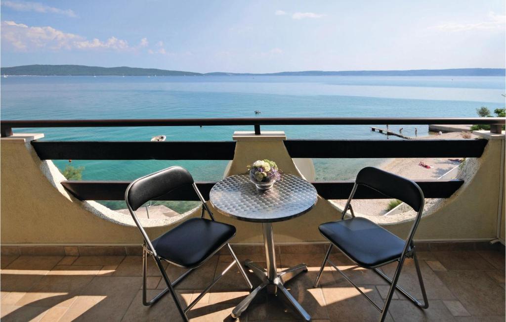 a table and chairs on a balcony with a view of the ocean at Lovely Apartment In Kastel Kambelovac With Wifi in Kaštela
