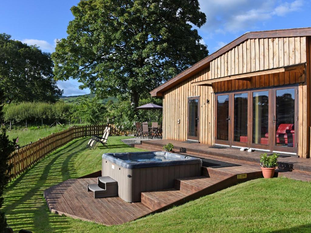 a house with a hot tub in the yard at Sycamore Lodge in Rhayader