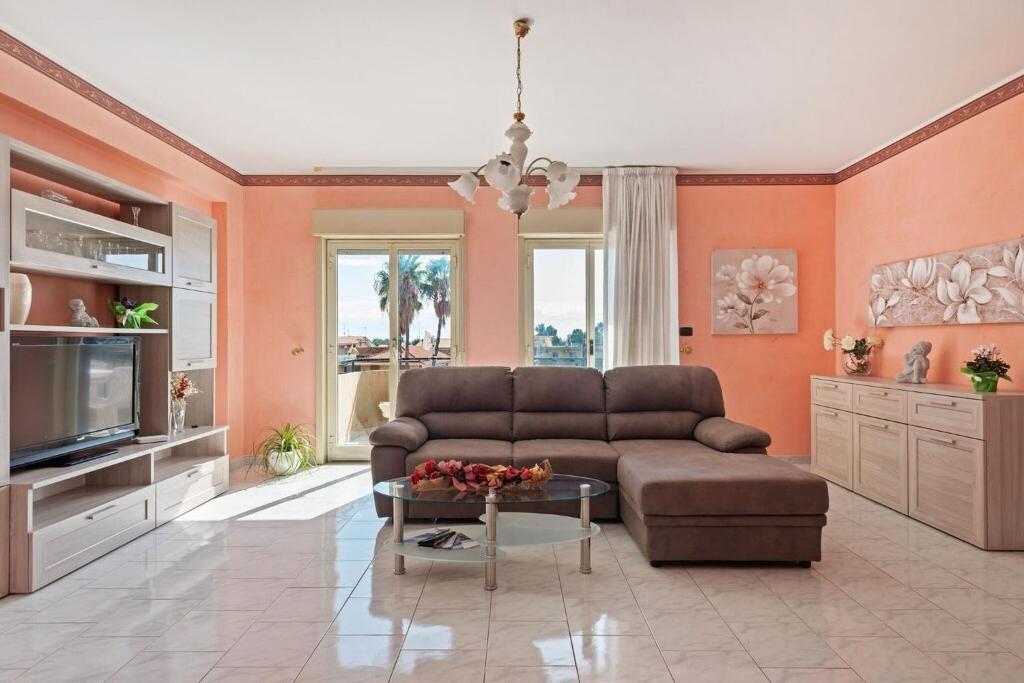 a living room with a couch and a tv at Appartamento Sicilia Etna e Mare in Mascali