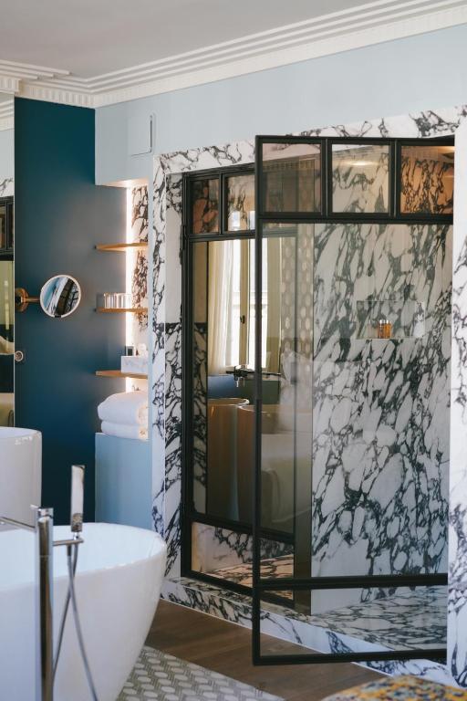 a bathroom with a tub and a glass shower at Hôtel Singulier Bordeaux - Boutique Hôtel & Spa Anne Semonin in Bordeaux