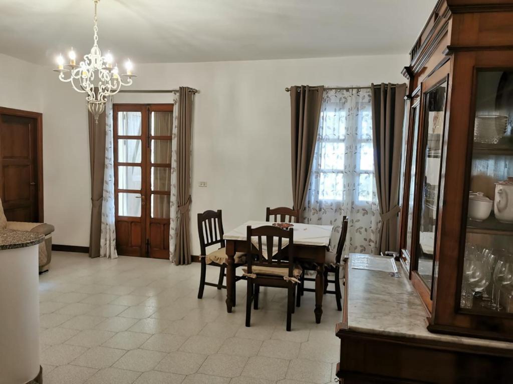 uma sala de jantar com uma mesa e cadeiras e um lustre em Giardino sul Mare em Realmonte