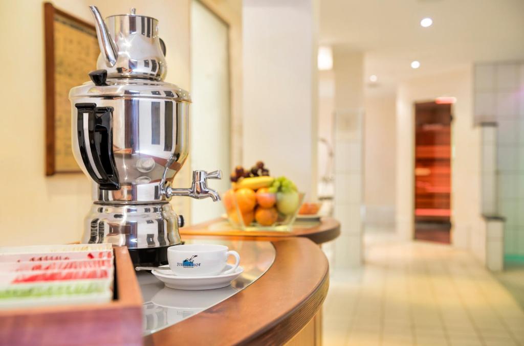 a coffee maker on a counter with a bowl of fruit at Strandhotel Juister Hof in Juist